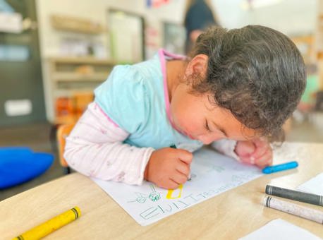 Evolve Education Preschool girl drawing on paper at daycare