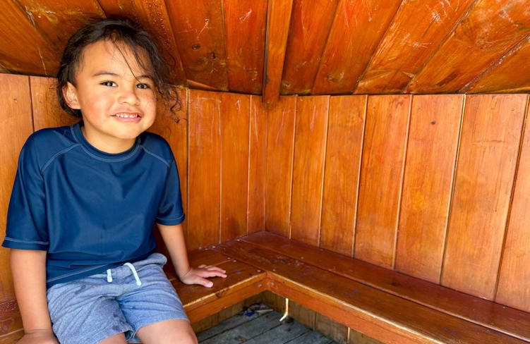 Evolve Education Preschool boy sitting in the whare at daycare